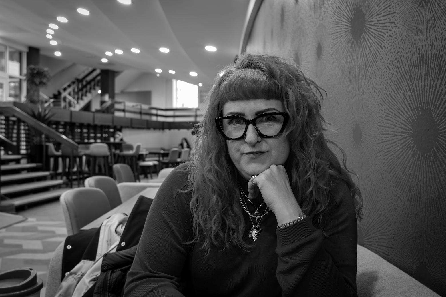 Portrait of Lorraine looking at the camera while leaning her chin in the palm of her hand.